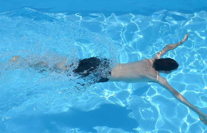 Privat svømmeundervisning- mand svømmer i bassin